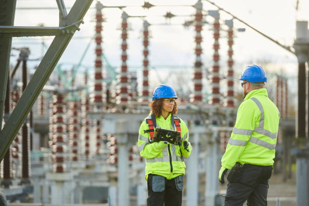 Electrical workers in safety gear collaborating on power infrastructure